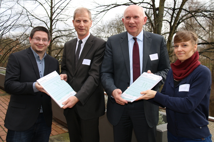 Christian Hellwig und Christine Schoemakers von der Leibniz-Universität Hannover übergeben den Bericht an Harald Ottmar vom ArL und Landrat Jürgen Schulz. (LK Lü-Dan)